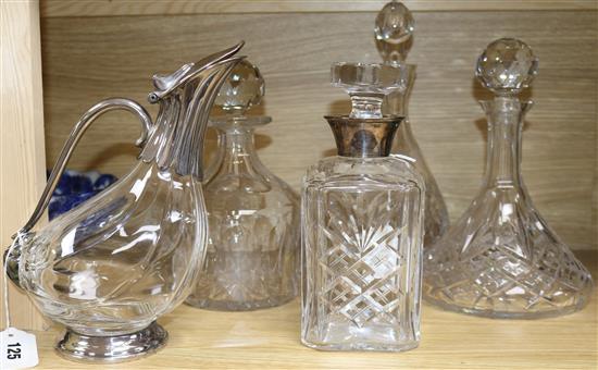 A silver-mounted spirit decanter, three other decanters and a claret jug